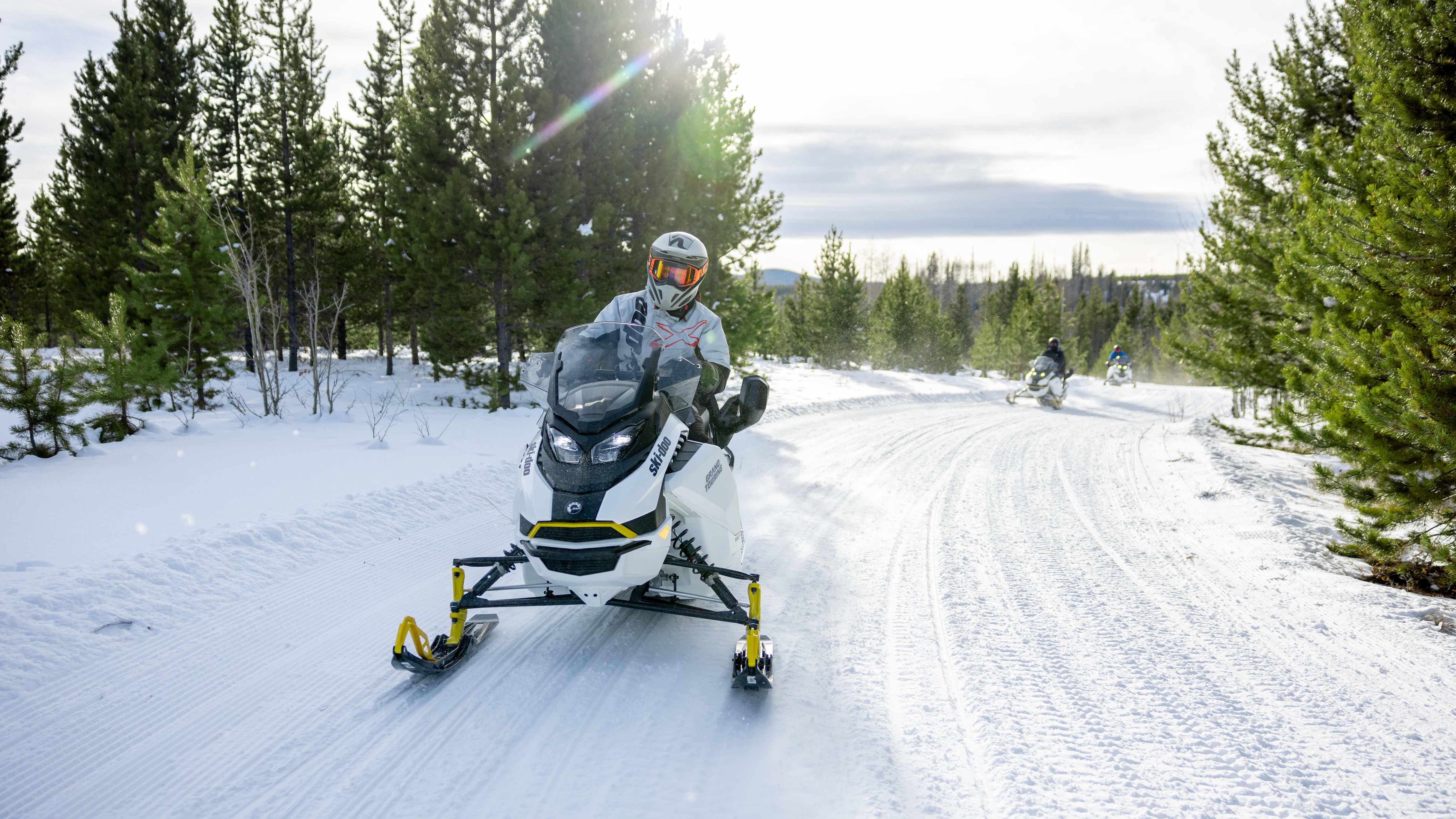 Two Ski-Doo snowmobiles on a groomed trail